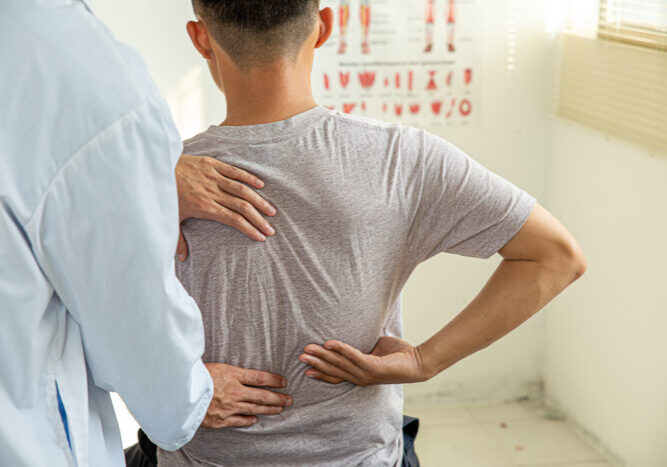 Male doctor therapist working examining treating injured back.Back pain patient, treatment, medical doctor,massage for back pain relief office syndrome.